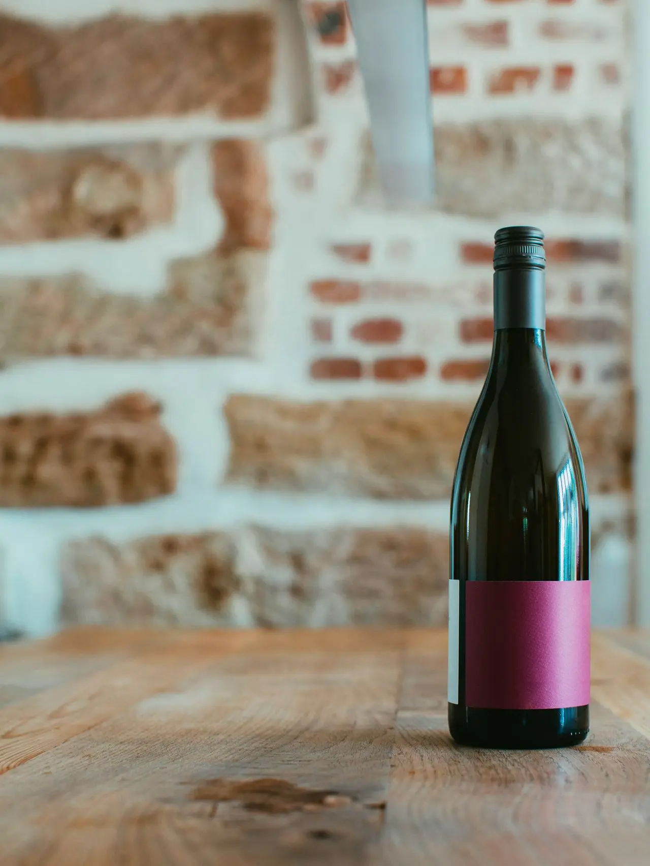 black and pink bottle on brown wooden table